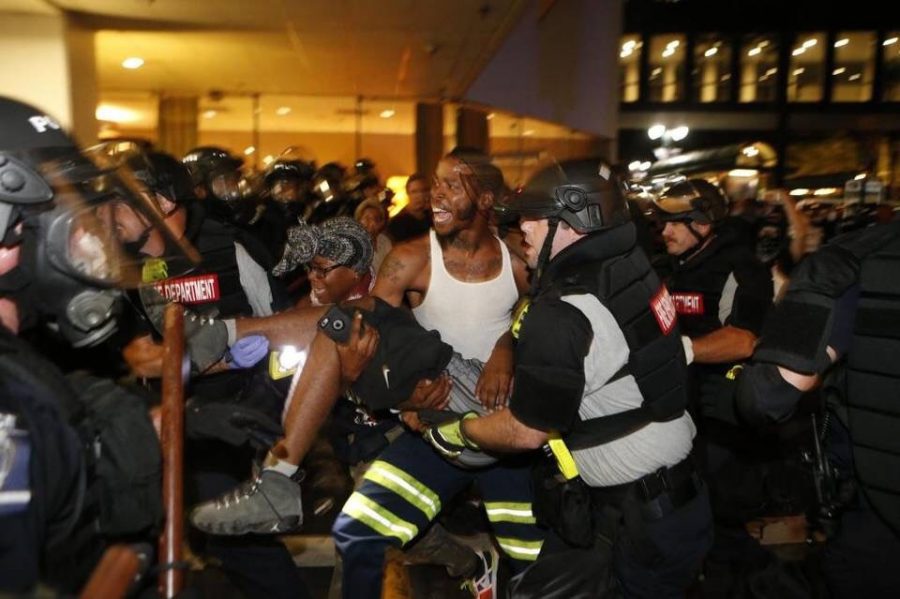 Officials help injured civilian during the riot in Charlotte, North Carolina