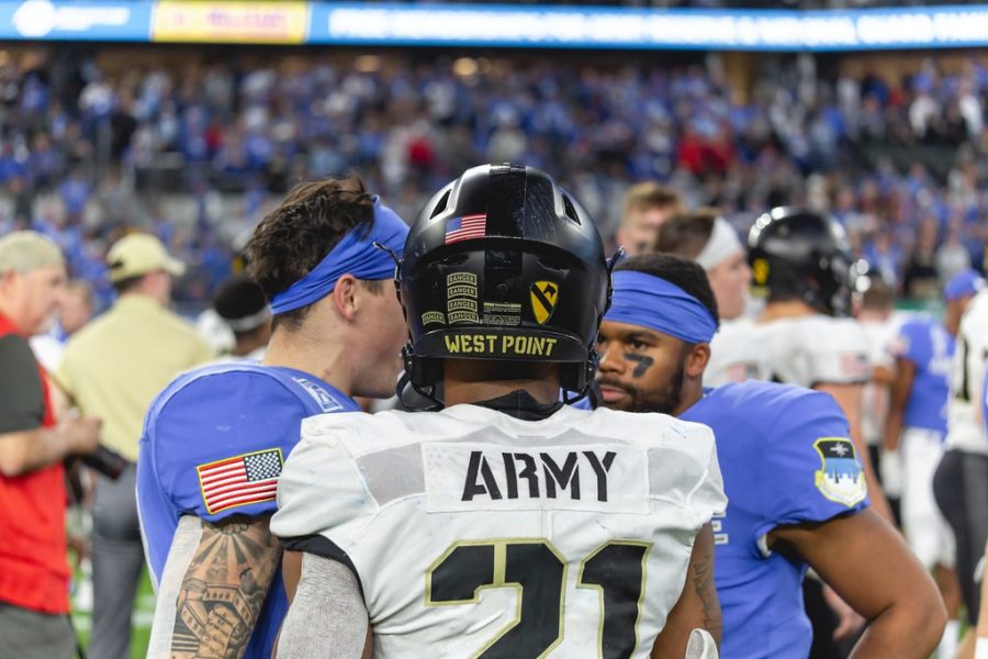 Football players from Army and Air Force talk after a grueling rivalry game.