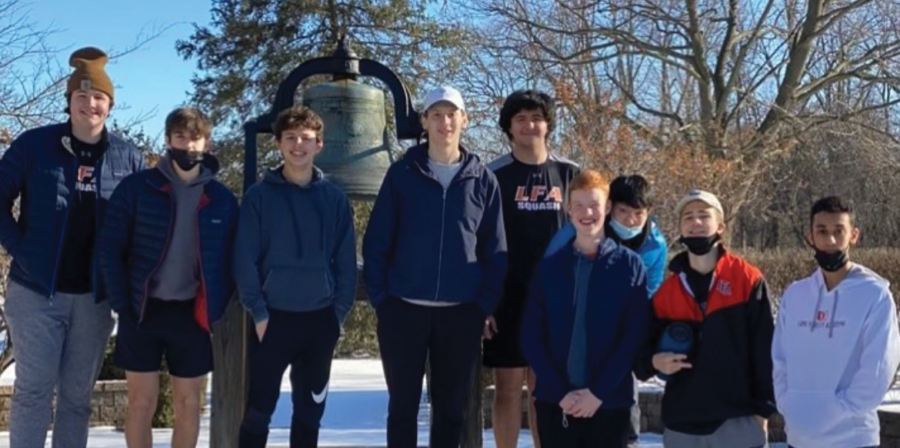 The squash team stands in front of LFAs famous bell. 