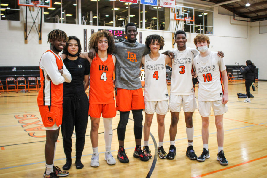 “Members of both Varsity Orange and Black linking arms posing after the event. Seniors Sano Rutatika in the middle, Darius Duff second furthest to the right, and Brendan Flaherty furthest right.” 
