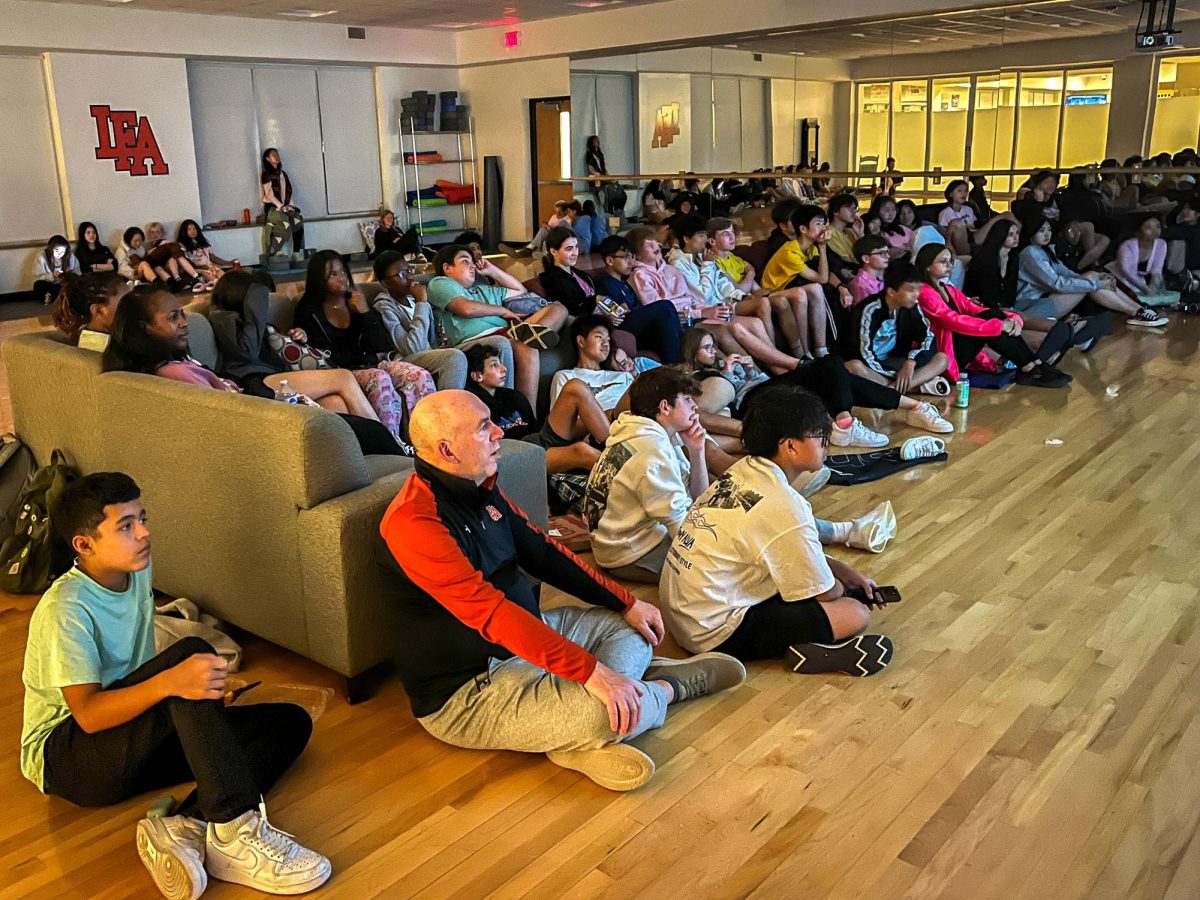 Students and faculty watch the Barbie movie in the dance room.  